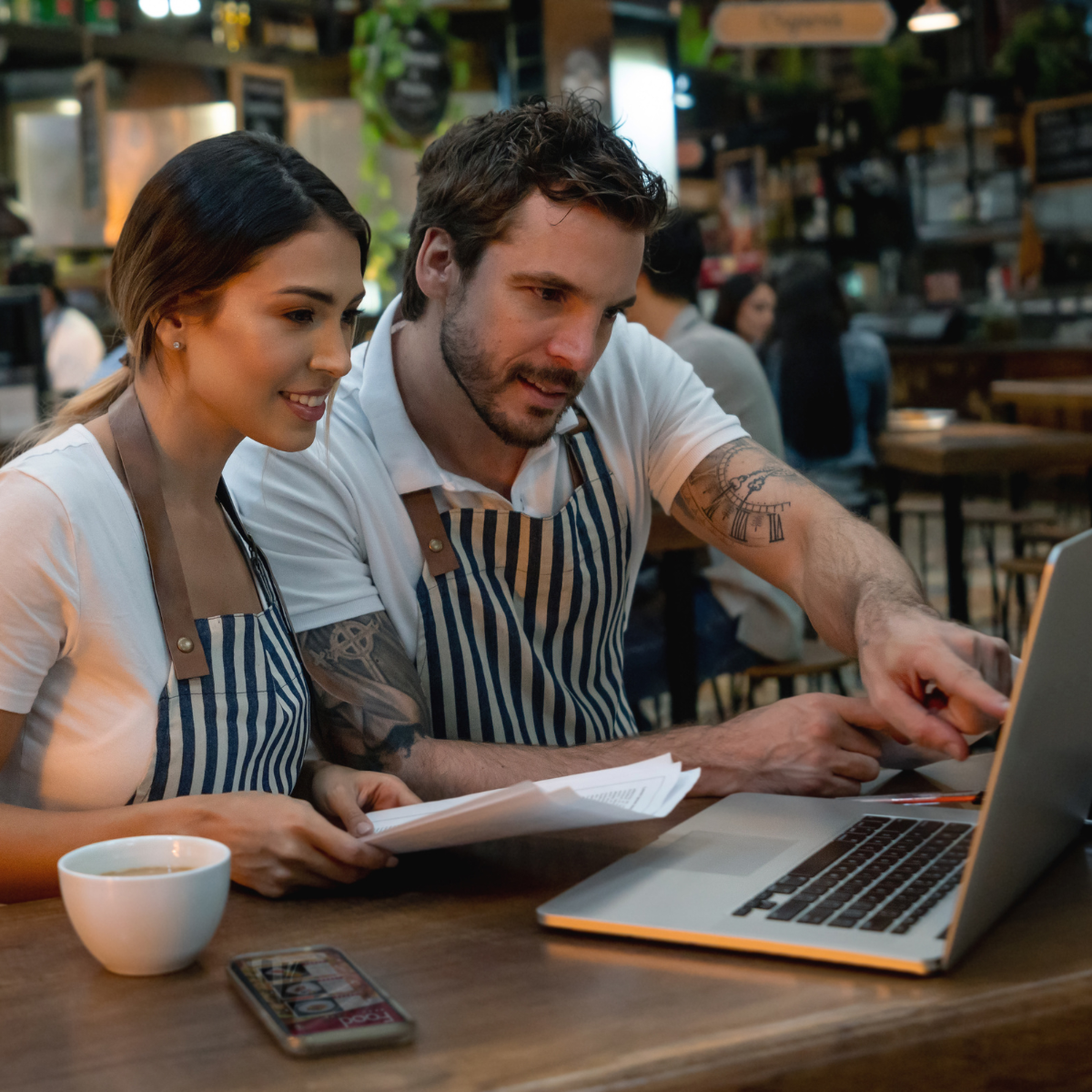 TRABAJADOREC CONTROLANDO LAS FINANZAS DE UN RESTAURANTE